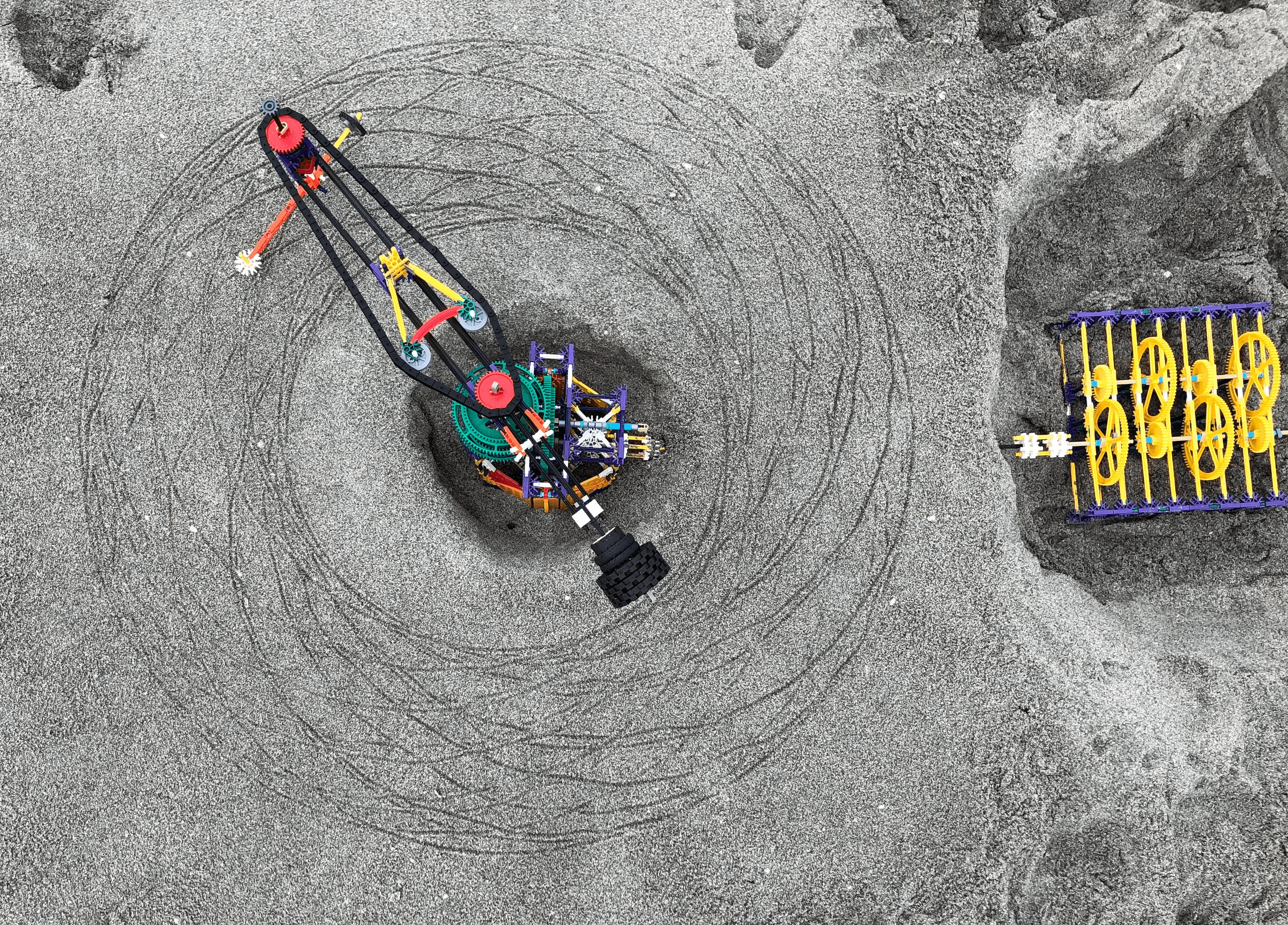Top-down view of the K'nex spirograph on sand